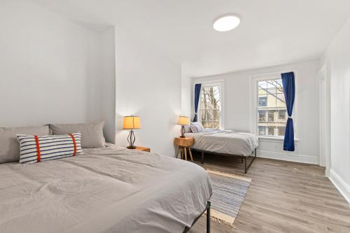 ein weißes Schlafzimmer mit 2 Betten und einem Fenster in der Unterkunft Orange Oasis in the Heart of East Rock with FREE parking near DT and Yale in New Haven
