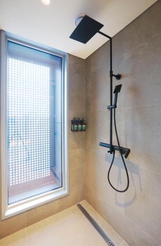 a bathroom with a shower with a window at voco Seoul Gangnam by IHG in Seoul