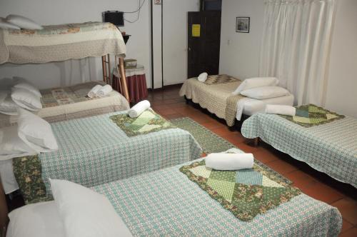a room with four beds in a room at Hospedaje La Casona in Tabio