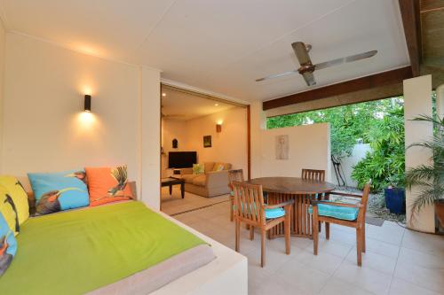 a bedroom with a bed and a table with chairs at Seascape Holidays Villa 8 Surya in Port Douglas