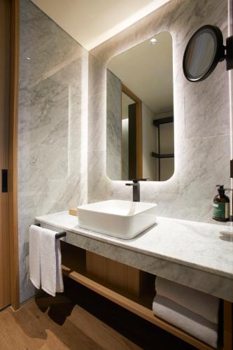 a bathroom with a sink and a mirror at voco Seoul Gangnam by IHG in Seoul