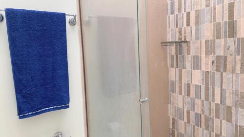 a blue towel is hanging on a shower door at Aloja-T en Casa de Playa Bahia Solano in Bahía Solano
