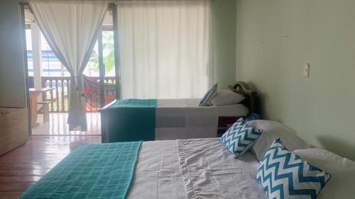a bedroom with two beds and a balcony at Aloja-T en Casa de Playa Bahia Solano in Bahía Solano