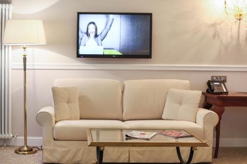 a living room with a couch and a tv on the wall at Hotel International Iasi in Iaşi