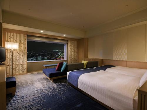 a hotel room with a bed and a couch and a window at Urayasu Brighton Hotel Tokyo Bay in Urayasu