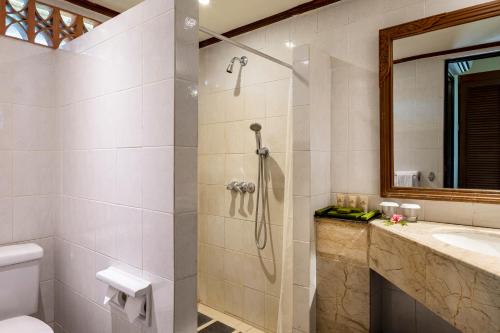 a bathroom with a shower and a toilet and a sink at Merumatta Senggigi Lombok in Senggigi 