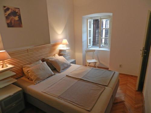 a bedroom with a large bed with a wooden headboard at Apartment Mimosa in Kotor