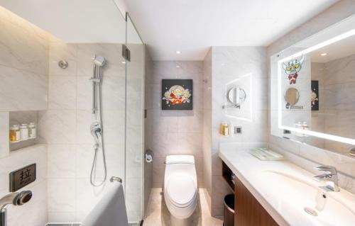 uma casa de banho com um chuveiro, um WC e um lavatório. em Holiday Inn Chengdu Century City West, an IHG Hotel em Chengdu