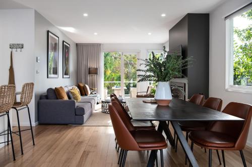 a living room with a table and chairs at Vue Lake Daylesford Villa- lakeside luxury in Daylesford