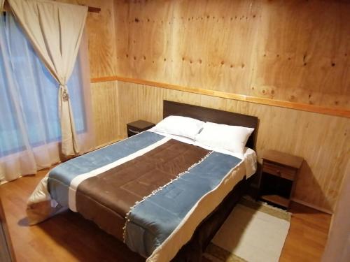 a bedroom with a bed in a room with a window at Cabañas camelia in Puelo