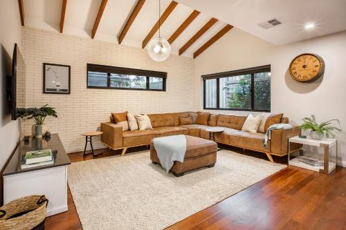 a living room with a couch and a clock on the wall at Starboard Drift in Margaret River Town