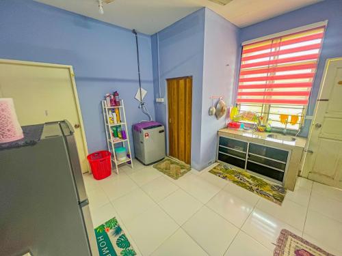 La cuisine est équipée d'un évier et d'un réfrigérateur. dans l'établissement Nail Homestay Kuala Besut, à Kampung Kuala Besut