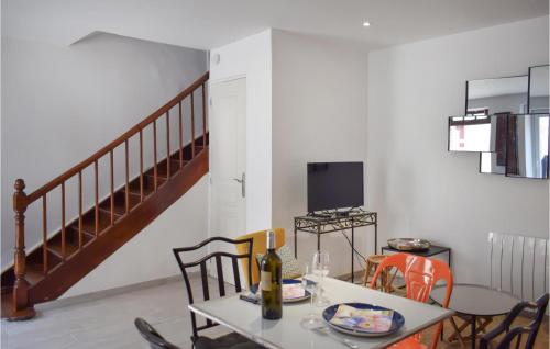 une salle à manger avec une table et des chaises et un escalier dans l'établissement 1 Bedroom Stunning Home In Ploubazlanec, à Ploubazlanec