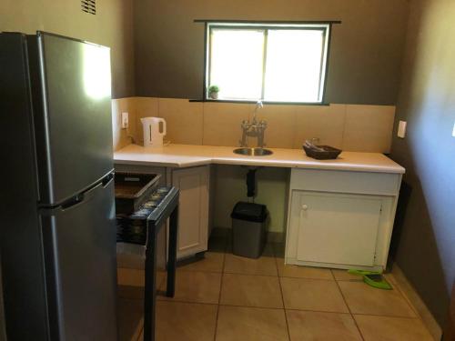 a small kitchen with a sink and a refrigerator at Ebenhaeser overnight accomodation in Bela-Bela