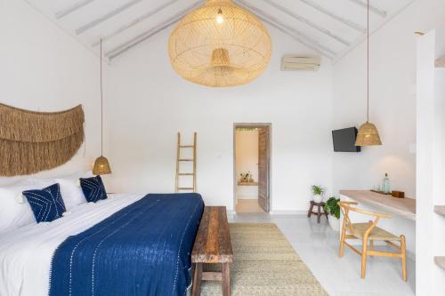 a bedroom with a blue bed and a table at Jepun Sari Uluwatu in Uluwatu