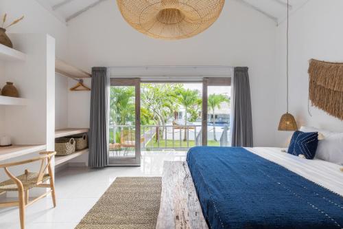 a bedroom with a large bed with a blue blanket at Jepun Sari Uluwatu in Uluwatu