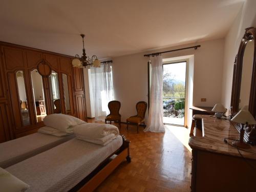 ein Schlafzimmer mit einem Bett und einem großen Fenster in der Unterkunft Attractive Holiday Home in Trarego Viggiona with Garden in Trarego Viggiona
