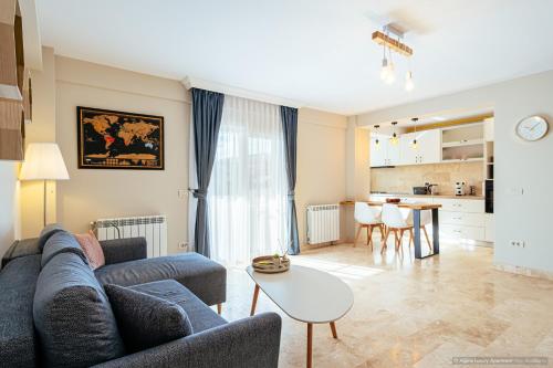 a living room with a couch and a table at Alpine Luxury Apartment Arinis in Gura Humorului