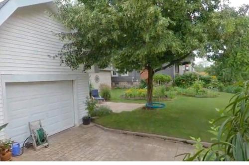 a house with a tree and a garage at Garden 2 Storey House in Niagara Falls