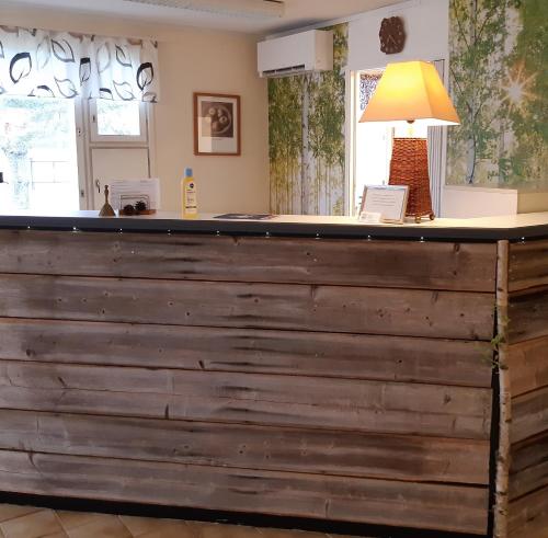 a large wooden bar in a room with a lamp at Gasthaus Henri in Raisio