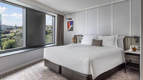 a bedroom with a large bed and a large window at Cordis, Auckland by Langham Hospitality Group in Auckland