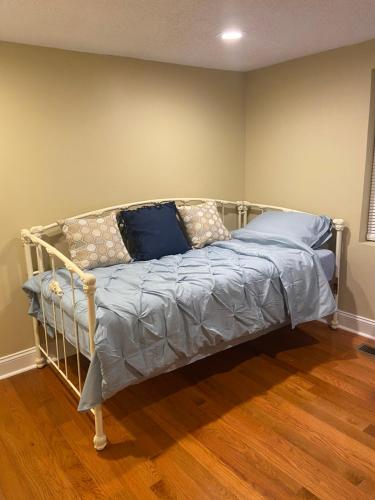 a bed with blue pillows on it in a room at Modern home with huge fenced yard and No pet fees in Durham
