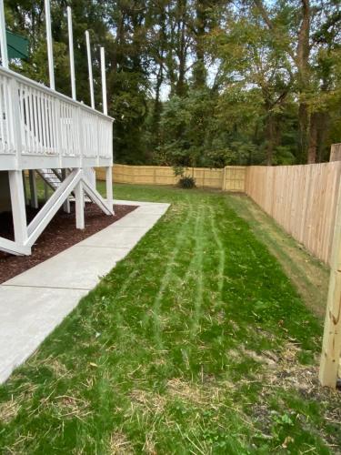 a yard with a fence and a white porch at Modern 3-bedroom, big fence yard, Pets stay free in Durham