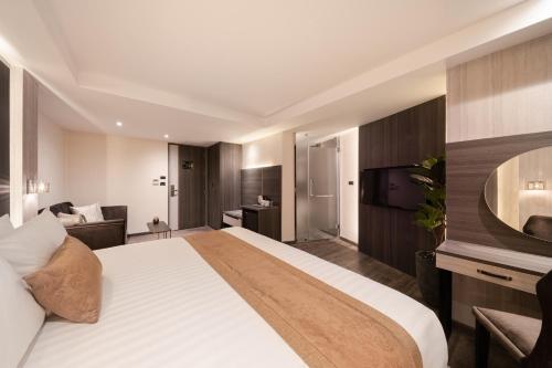 a hotel room with a large bed and a television at Aspira Parc Sukhumvit 22 in Bangkok