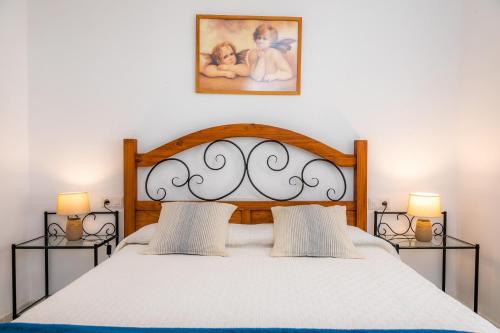 カン・ピカフォルトにあるFinca el Cactusのベッドルーム1室(大型ベッド1台、ランプ2つ付)