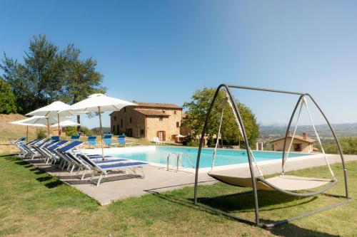 a swimming pool with chairs and a swing at Agriturismo Villalugnano in Lugnano