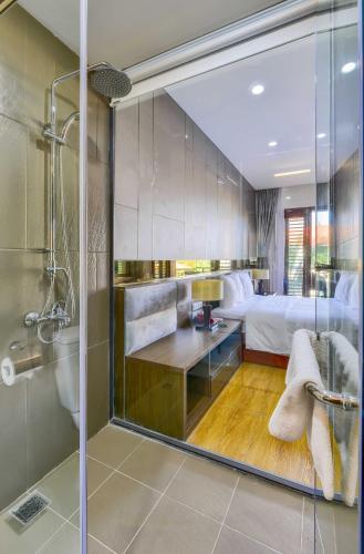 a bathroom with a shower and a bedroom with a bed at MANLI Resort Quảng Bình in Dong Hoi