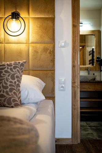 a bedroom with a bed with a pillow and a mirror at Dworek nad Jałowcami z Jacuzzi in Biały Dunajec