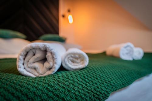 a pile of towels sitting on top of a bed at Dworek nad Jałowcami z Jacuzzi in Biały Dunajec