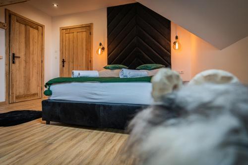a bedroom with a large bed with a wooden headboard at Dworek nad Jałowcami z Jacuzzi in Biały Dunajec