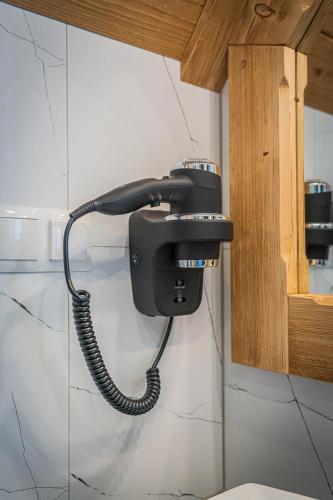 a telephone hanging on a wall in a bathroom at Dworek nad Jałowcami z Jacuzzi in Biały Dunajec