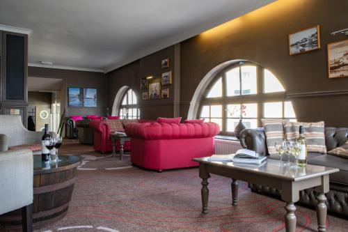 a living room with pink couches and a table at Ship and Castle Hotel in Saint Mawes