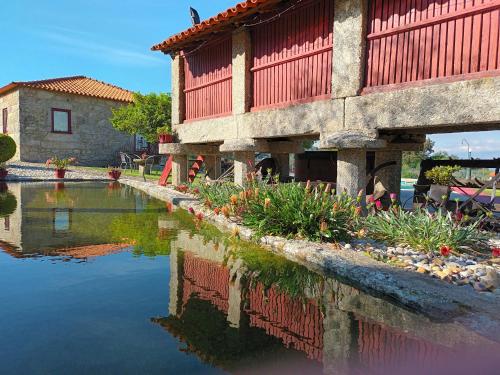 a building with a pond in front of a building at Casa D`Auleira in Ponte da Barca