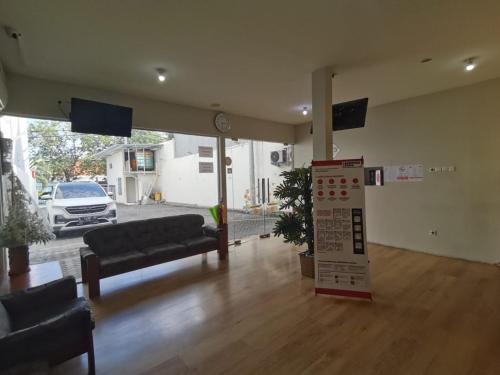 a large living room with couches and a tv at Kozy 15 Guesthouse in Surabaya