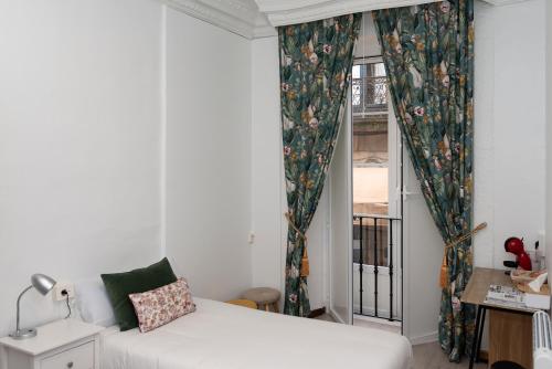 a living room with a bed and a window at Hostal Santa Cruz in Santiago de Compostela