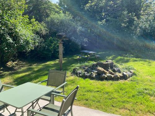 - une table de pique-nique et des chaises dans une cour avec foyer extérieur dans l'établissement Woodland Cottage Charleton Estate, à Colinsburgh