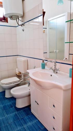 a bathroom with a sink and a toilet and a mirror at La Bitta in Lipari