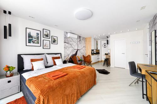 ein Schlafzimmer mit einem Bett mit einer orangefarbenen Decke in der Unterkunft TELEKI40 Apartman Győr CENTRAL, FREE PARKING, TERRACE in Győr