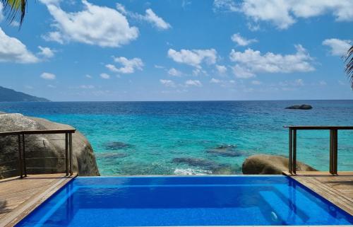 a swimming pool with the ocean in the background at Marquise & Infinity villas in Glacis