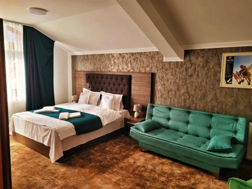 - une chambre avec un lit et un canapé vert dans l'établissement Hotel Margaritar, à Buşteni