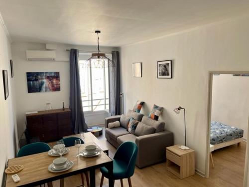 uma sala de estar com um sofá e uma mesa em Un havre de paix et de calme en plein centre de Massena em Nice