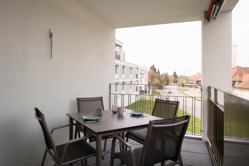 a table and chairs on a balcony with a view at Senevita Ahornpark in Bätterkinden