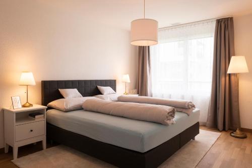 a bedroom with a large bed and a window at Senevita Ahornpark in Bätterkinden