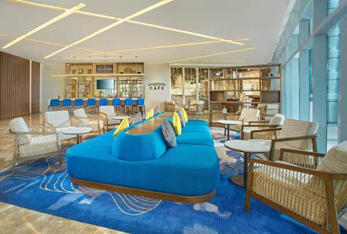 a lobby with a blue couch and tables and chairs at Kingsford Hotel Manila in Manila
