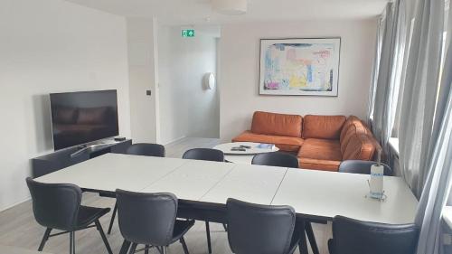 een woonkamer met een tafel en stoelen en een bank bij Post-Plaza Guesthouse in Húsavík