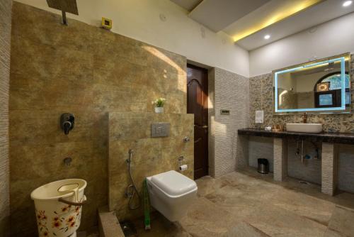 a bathroom with a toilet and a sink at Sunahari Bagh - Pool Farm Retreat @ Gurgaon in Gurgaon